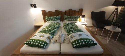 two beds with green and white pillows in a room at Zugspitzchalets in Biberwier