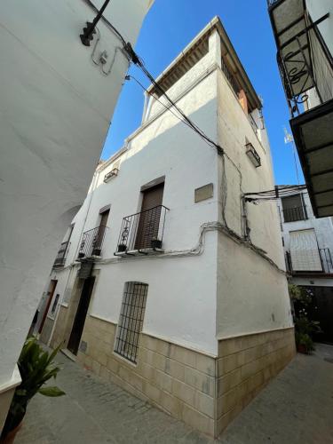 - un bâtiment blanc avec balcon dans une rue dans l'établissement Casa Rincón, à Iznatoraf