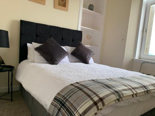 a bedroom with a large bed with a black headboard at clyde hub in Gourock