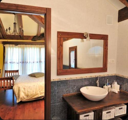 a bathroom with a sink and a mirror and a bed at Casa Corral - Casas de Aldea in Monón