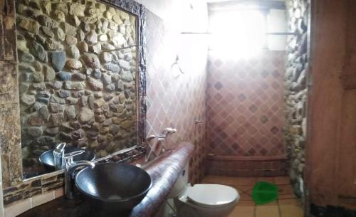 a stone bathroom with a sink and a toilet at Hermoso lugar familiar cerca a Villa de Leyva in Sutamarchán