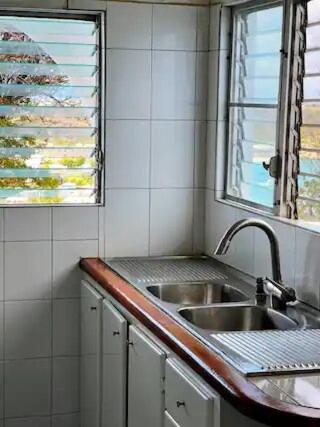 uma pequena cozinha com um lavatório e uma janela em Villa Kaiae em Sandy Ground Village