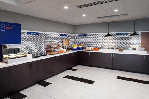 a large kitchen with brown cabinets and a counter at Holiday Inn Express Washington DC Downtown by IHG in Washington