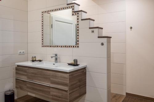 ein Bad mit einem Waschbecken und einem Spiegel in der Unterkunft Penthouse „Das Besenhaus“ in Altenmarkt im Pongau