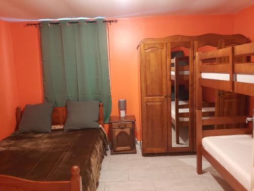 a bedroom with two bunk beds and a bed with a mirror at Pomme de Pin in Cilaos