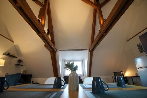 un comedor con una mesa con un jarrón. en Au toit de l’Alsace - Loft au pied des Vosges, en Wattwiller