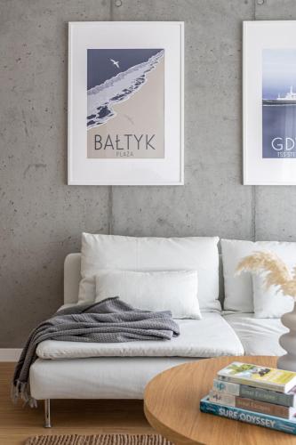 a living room with a white couch and a table at S35 Apartments Gdynia Orłowo in Gdynia