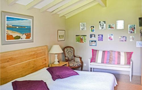 een slaapkamer met een bed en een stoel en foto's aan de muur bij Stunning Home In Ascain With 5 Bedrooms, Wifi And Private Swimming Pool in Ascain