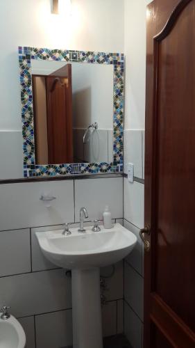 a bathroom with a sink and a mirror at Casa Folks Bed and Breakfast in Puerto Iguazú