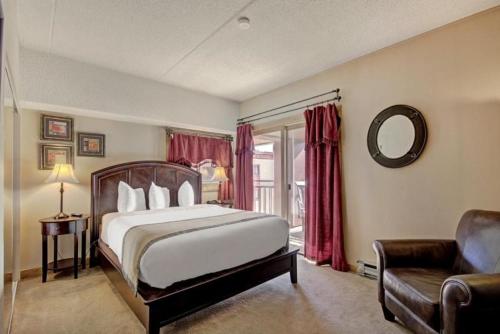 a bedroom with a bed and a chair and a mirror at 4 Bedroom Ski In, Ski Out Mountain Vacation Rental Located Next To Historic Main Street In Downtown Breckenridge in Breckenridge