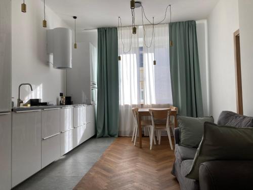 a kitchen and dining room with a table and green curtains at Apartament z klimatyzacją in Krakow