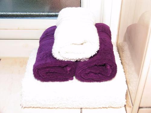 una toalla púrpura y blanca sentada en un alféizar de la ventana en Must see, Quality 1 bed, Romford, 20 mins C.London en Romford