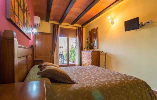a bedroom with a bed and a dresser and a window at El Corral de Valero in Valdealgorfa