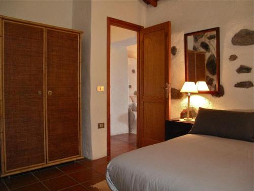 a bedroom with a bed and a closet with a door at Casa Rural El Tabaibal in Hermigua