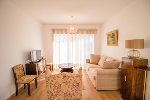 a living room with a couch and a table at 188 Apartments - Estrelícia - pool and balcony in Cascais