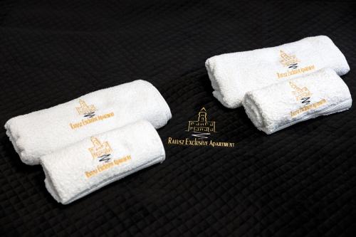 three towels are sitting on a black surface at Ratusz Exclusive Apartment- Apartament przy Ratuszu in Głogów
