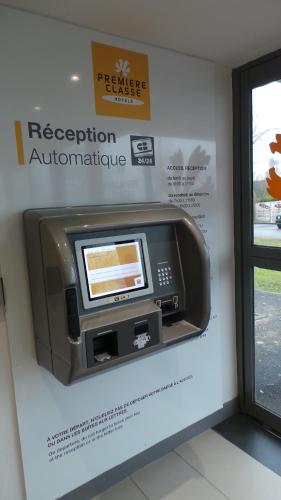 a pay station with a television on a wall at Première Classe Amiens in Amiens
