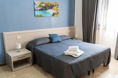 a blue bedroom with a bed with towels on it at Villa Pollina in Buseto Palizzolo