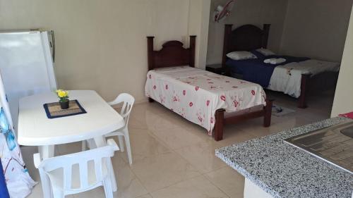 Habitación con 2 camas, mesa y sillas en Casa taina en Jarabacoa