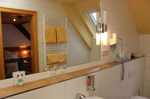 a bathroom with a sink, mirror and bathtub at Landgasthof zum Schützen in Oberried