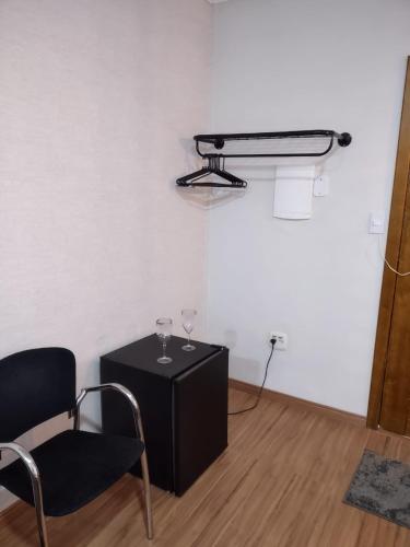 a room with a table and a chair and a projector at Ipê Suítes in Domingos Martins