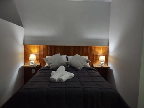 a bedroom with a bed with two white towels on it at Ipê Suítes in Domingos Martins