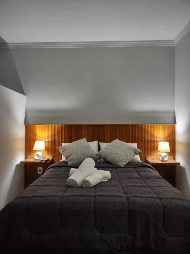 a bedroom with a large bed with two towels on it at Ipê Suítes in Domingos Martins