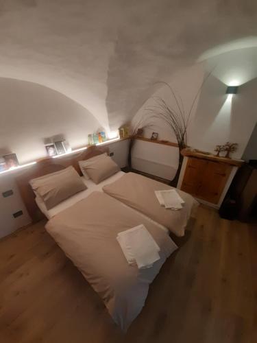 Schlafzimmer mit einem Bett mit weißer Bettwäsche und Kissen in der Unterkunft PANEERIPOSO in Pergine Valsugana