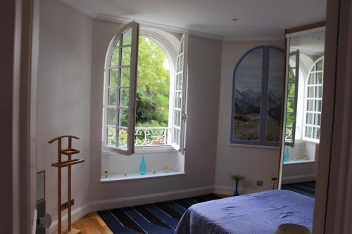 - une chambre avec deux fenêtres et un lit dans l'établissement Villa Délice, à Quincy-sous-Sénart