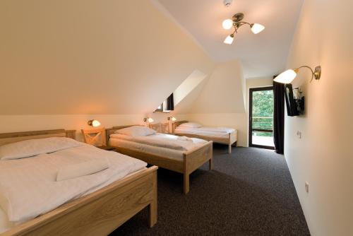 a bedroom with two beds and a window at Dworek staropolski in Poznań