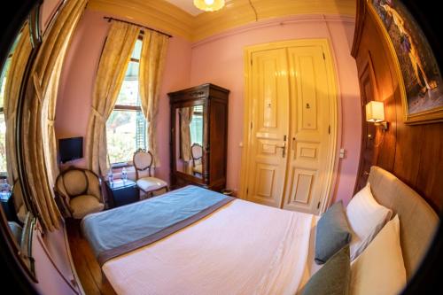 a bedroom with a bed and chairs in it at Büyükada Anastasia Meziki History Mansion in Buyukada