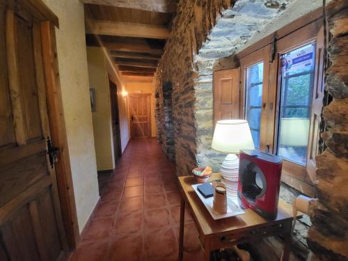 a hallway with a table with a tv on it at Hotel Rural LA CÁRCEL in Murias de Paredes