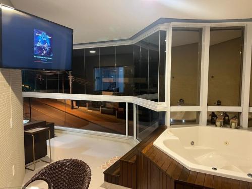 baño grande con bañera y TV en 1072 - Apartamento 3 suítes Alto Padrão com SPA na Praia de Bombinhas, en Bombinhas