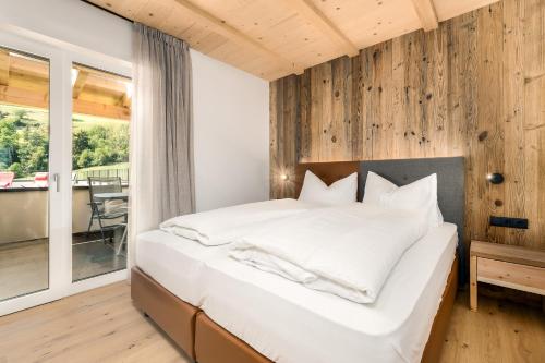 ein Schlafzimmer mit einem großen Bett und einem Balkon in der Unterkunft Stillehof - Ferienwohnungen auf dem Bauernhof- Südtirol in Brixen