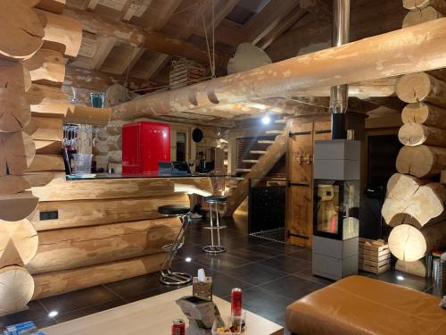 a living room with wooden walls and a staircase at Chalet Anzac Chalet 5 Etoiles en Rondins Tout Neuf Unique dans les Aravis in Les Villards-sur-Thônes