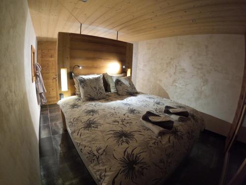 une chambre avec un grand lit dans une pièce dans l'établissement Chalet Anzac Chalet 5 Etoiles en Rondins Tout Neuf Unique dans les Aravis, à Les Villards-sur-Thônes