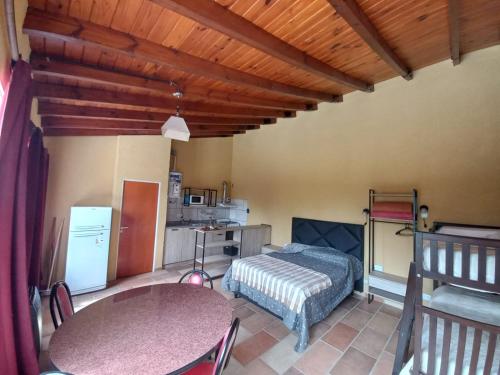 Un dormitorio con una cama y una mesa y una cocina. en Complejo Los Manantiales, en Alta Gracia