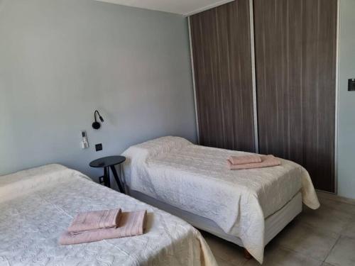 two beds in a room with two towels on them at Hécate in San Fernando del Valle de Catamarca