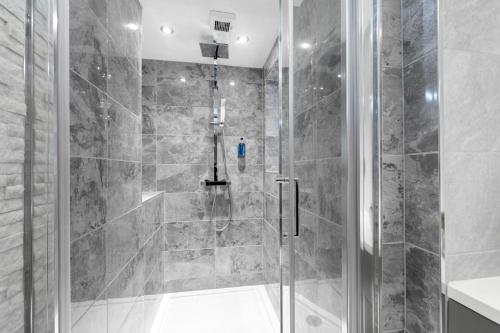a bathroom with a shower with a glass door at Prestbury Road in Cheltenham