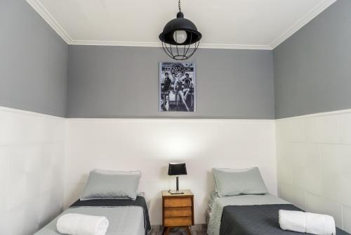 sypialnia z 2 łóżkami pojedynczymi i lampką w obiekcie Huarpes Mendoza w mieście Mendoza