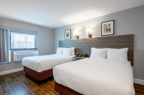 um quarto de hotel com duas camas e uma janela em The Lodge Red Hook em Brooklyn