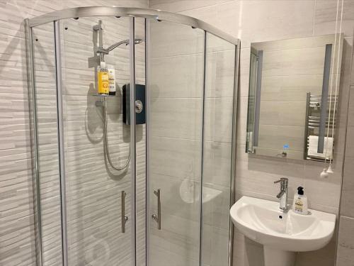 uma casa de banho com um chuveiro e um lavatório. em Erne Getaway No.6 Brand new 1 bed apartment em Enniskillen