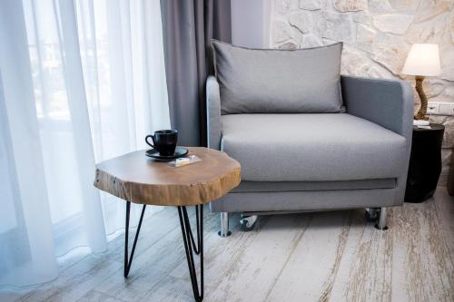 a living room with a chair and a coffee table at Kali Thea Suites in Neos Marmaras