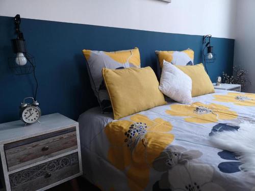 - un lit avec des oreillers jaunes et un mur bleu dans l'établissement Orleans Studio - Near Train Station - Free Parking, à Orléans