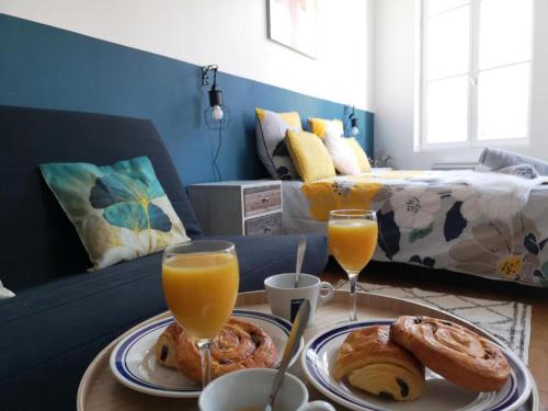 une table avec une assiette de nourriture et deux verres de jus d'orange dans l'établissement Orleans Studio - Near Train Station - Free Parking, à Orléans
