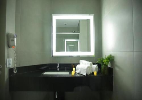 a bathroom with a sink and a mirror at Comfort Suites Flamboyant Goiânia in Goiânia