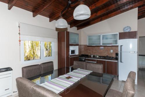 Una cocina con mesa y sillas y un refrigerador. en Complejo de cabañas Atrapasueños, en El Calafate