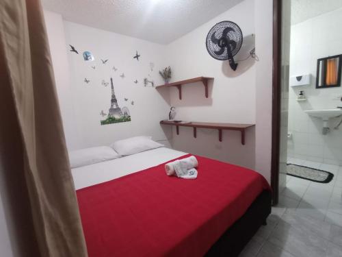 Habitación pequeña con cama con manta roja en Casa Hotel S&E, en Ibagué