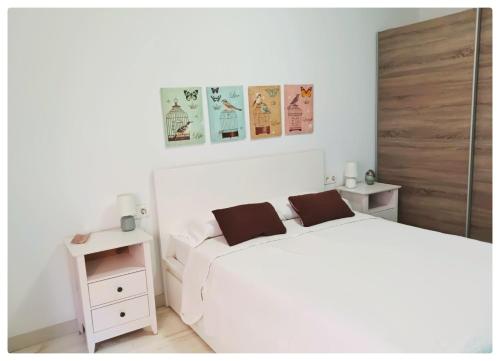 グラナダにあるSanto Domingo Suitesの白いベッドと木製のドアが備わる白いベッドルーム1室が備わります。