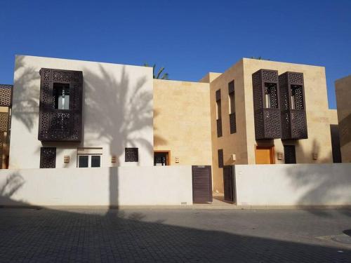 un bâtiment avec des fenêtres noires et un mur blanc dans l'établissement Nayah Stays, Amazing villa with private pool & 5 master suites, à Hurghada